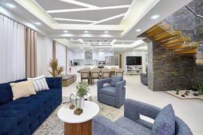 A modern living room with a blue sofa, grey armchairs, and a coffee table. - ®{San~Angel~View} @DowntownSD +BBQ+Close-to-Mall (Santo Domingo)