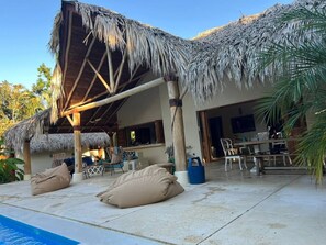 A resort with a pool, lounge chairs, and a covered outdoor area with thatched roofs. - 4BR{Beach~by~Melo} @LosNomadas +2Min Beach+Pool (Las Terrenas)
