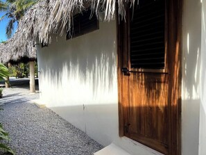 A white building with a wooden door and a thatched roof structure. - 4BR{Beach~by~Melo} @LosNomadas +2Min Beach+Pool (Las Terrenas)