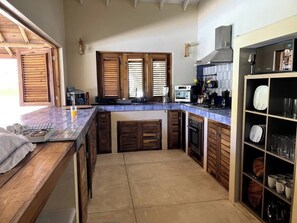 A kitchen with wooden cabinets, a countertop, and a built-in oven. - 4BR{Beach~by~Melo} @LosNomadas +2Min Beach+Pool (Las Terrenas)