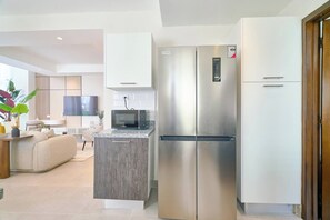 A modern kitchen with a built-in microwave, a stainless steel refrigerator, and a wooden cabinet. - ®(The~LUX~Natural~Art) @DowntownSD +Pool+Gym+2BR (Santo Domingo)