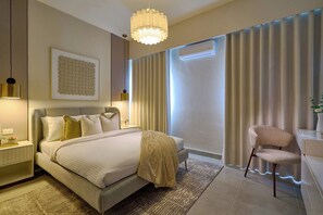A modern hotel room with a large bed, bedside tables, a desk, and a chair. - ®(The~LUX~Natural~Art) @DowntownSD +Pool+Gym+2BR (Santo Domingo)