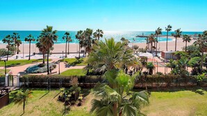 A coastal view with palm trees, a beach, and a clear sky. - Genteel Home Playa Rocio (Marbella)