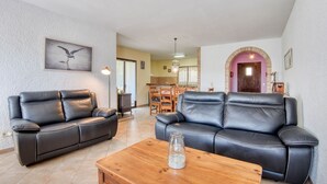 Ein Wohnzimmer mit zwei schwarzen Ledersofas, einem Holztisch und einem gerahmten Bild an der Wand.