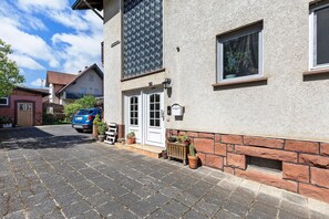 En bygning med stenfacade, garage og parkeret bil.