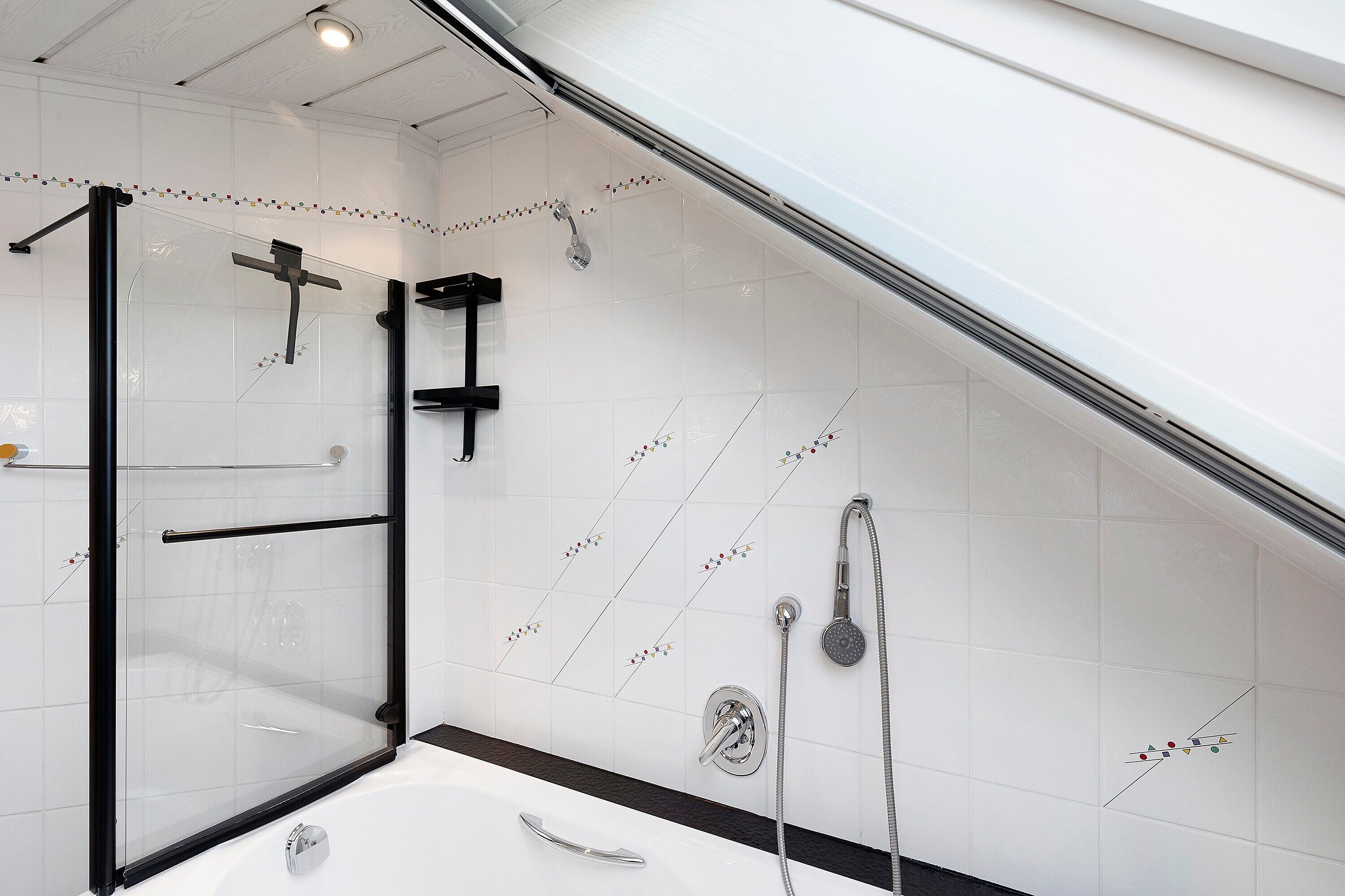 Ein modernes Badezimmer mit Duschkabine, einer Badewanne und einer Duschbrause.