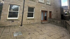 A multi-story brick building with a courtyard, a small door, and a window. - The Coach House - ultimate home away from home! (Huddersfield)
