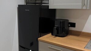 A compact kitchen with a refrigerator, a coffee maker, a potted plant, and a wooden countertop. - The Coach House - ultimate home away from home! (Huddersfield)