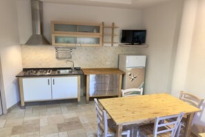 A compact kitchen with a gas stove, stainless steel cabinets, a microwave, and a small refrigerator. - Abbaechelu to Santa Margherita Pula (Pula (CA))