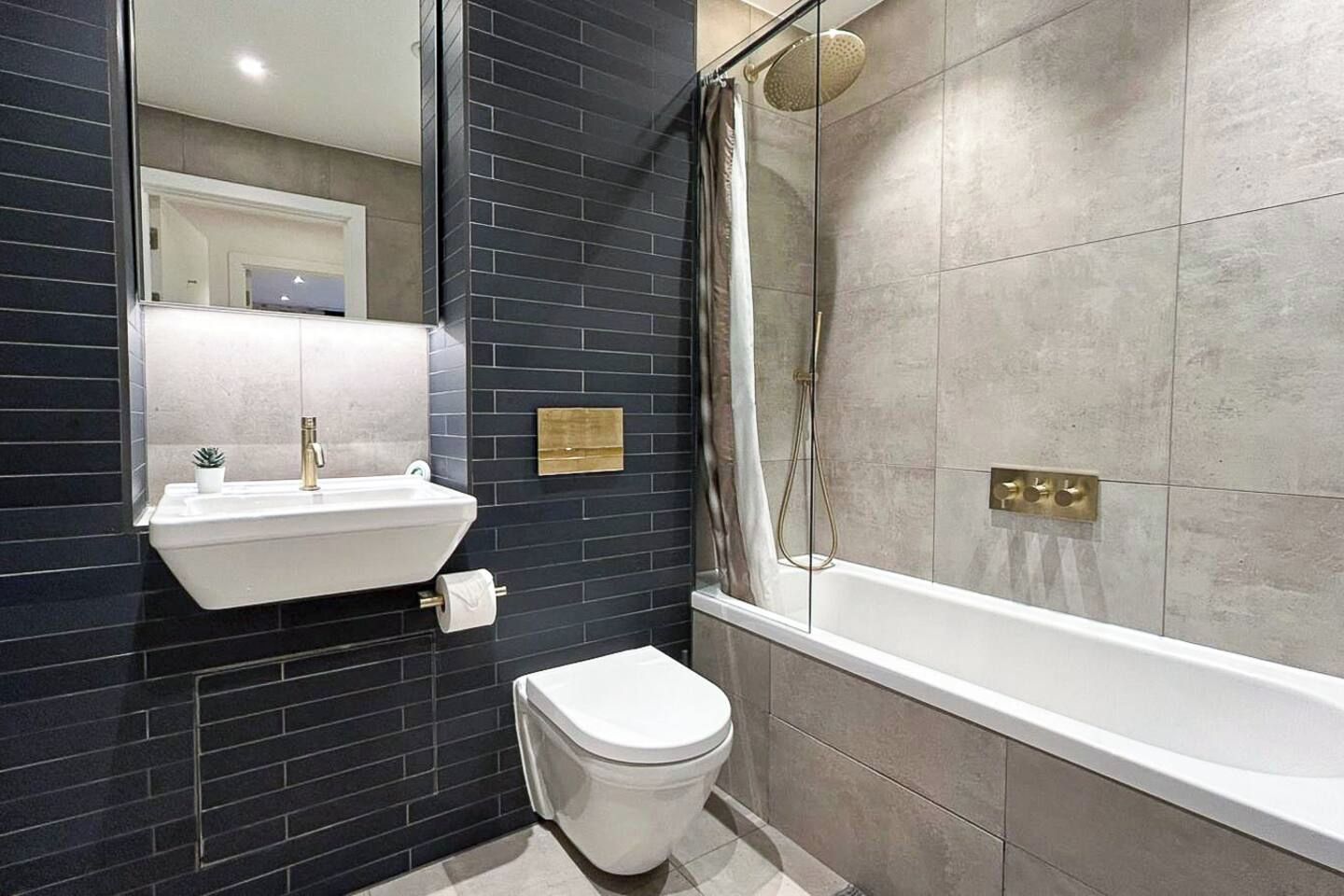 A modern bathroom with a sink, toilet, and shower area.