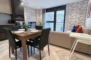 A modern living space with a dining area, a sofa, and a kitchen. - Furnished Apt Near Tower Bridge & aldgate station (London)
