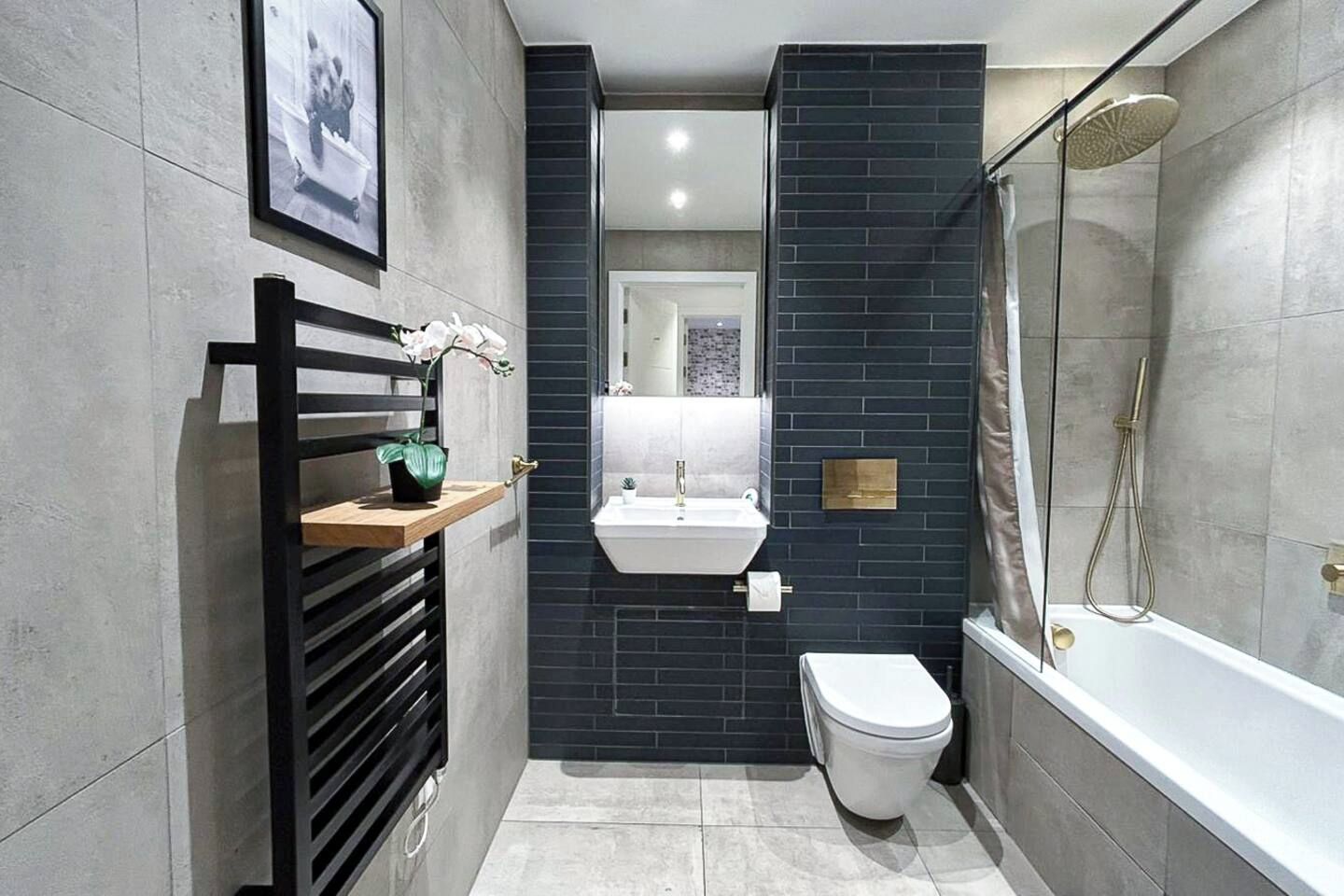 Un bagno moderno con il water bianco, un lavandino e una doccia.