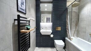 Ein modernes Badezimmer mit Toilette, Waschbecken und Dusche.