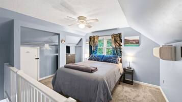 A bedroom with a bed, a nightstand, a ceiling fan, a window with curtains, and a wall-mounted air conditioning unit.