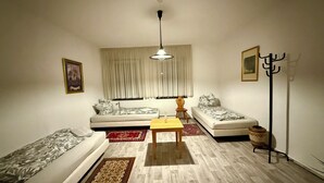 A living room with two sofas, a coffee table, a floor lamp, and a radiator.