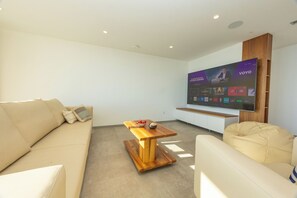 A modern living room with a sofa, a coffee table, and a flat-screen TV mounted on the wall. - Exclusive Penthouse Sara with 3 Bedrooms, Sea View, Hot Tub & Modern Luxury (Makarska)