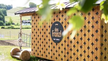 Eine Holzkonstruktion mit einem Schild, auf dem 'das Franzl Tiny House' steht.