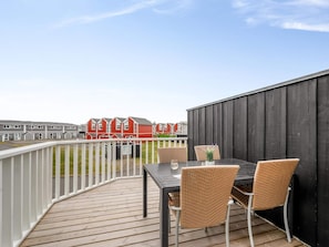 Eine Terrasse mit Tisch und Stühlen mit Blick auf eine Reihe roter Häuser.
