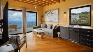 A modern living room with a sofa, coffee table, and a view of the ocean through large windows. - Holiday Home 'La Torre' with Private Terrace, Private Garden and Wi-Fi (Santa Cruz de Tenerife)