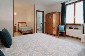 Une chambre à coucher avec un lit, une armoire, une chaise et une fenêtre.