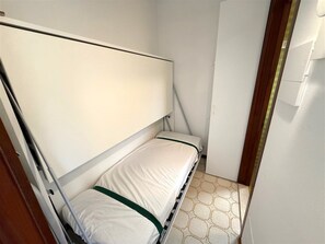 A narrow room with a bunk bed, a door, and a tiled floor. - Relaxing Stay in a Flat With Terrace and Pool (Lignano Sabbiadoro)
