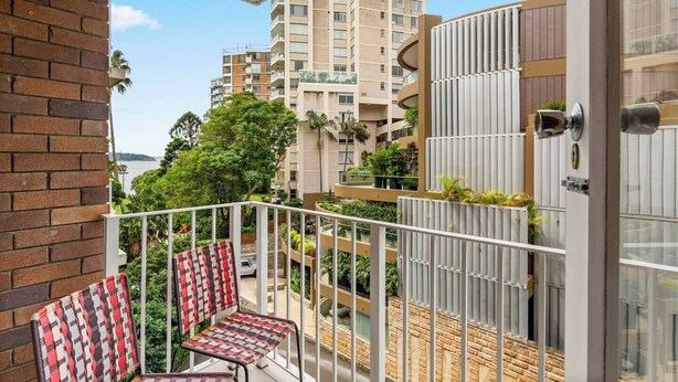 Un balcone con vista sulla città, un muro in mattoni e una porta con maniglia in metallo.