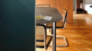 Un interno moderno con un tavolo da pranzo, sedie, un orologio e un lampadario.