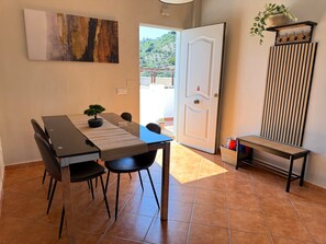 Un coin repas avec une table, des chaises et une plante en pot.