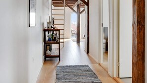 A hallway with exposed wooden beams, a shelf with various items, and a view to an outdoor area. - 4 Star Holiday Home in Lokken (Lokken)