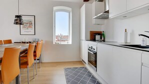A modern kitchen with white cabinets, a built-in oven, and a window with a city view. - 4 Star Holiday Home in Lokken (Lokken)