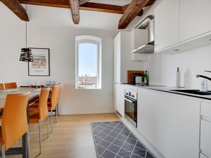 A modern kitchen with white cabinets, a built-in oven, and a window with a city view. - 4 Star Holiday Home in Lokken (Lokken)