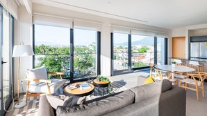 A modern living room with large windows, a dining area, and a kitchen. - 402 (Puerto Vallarta)