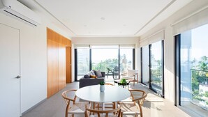 A modern living room with a round table and chairs, a sofa, and a balcony with a view. - 402 (Puerto Vallarta)
