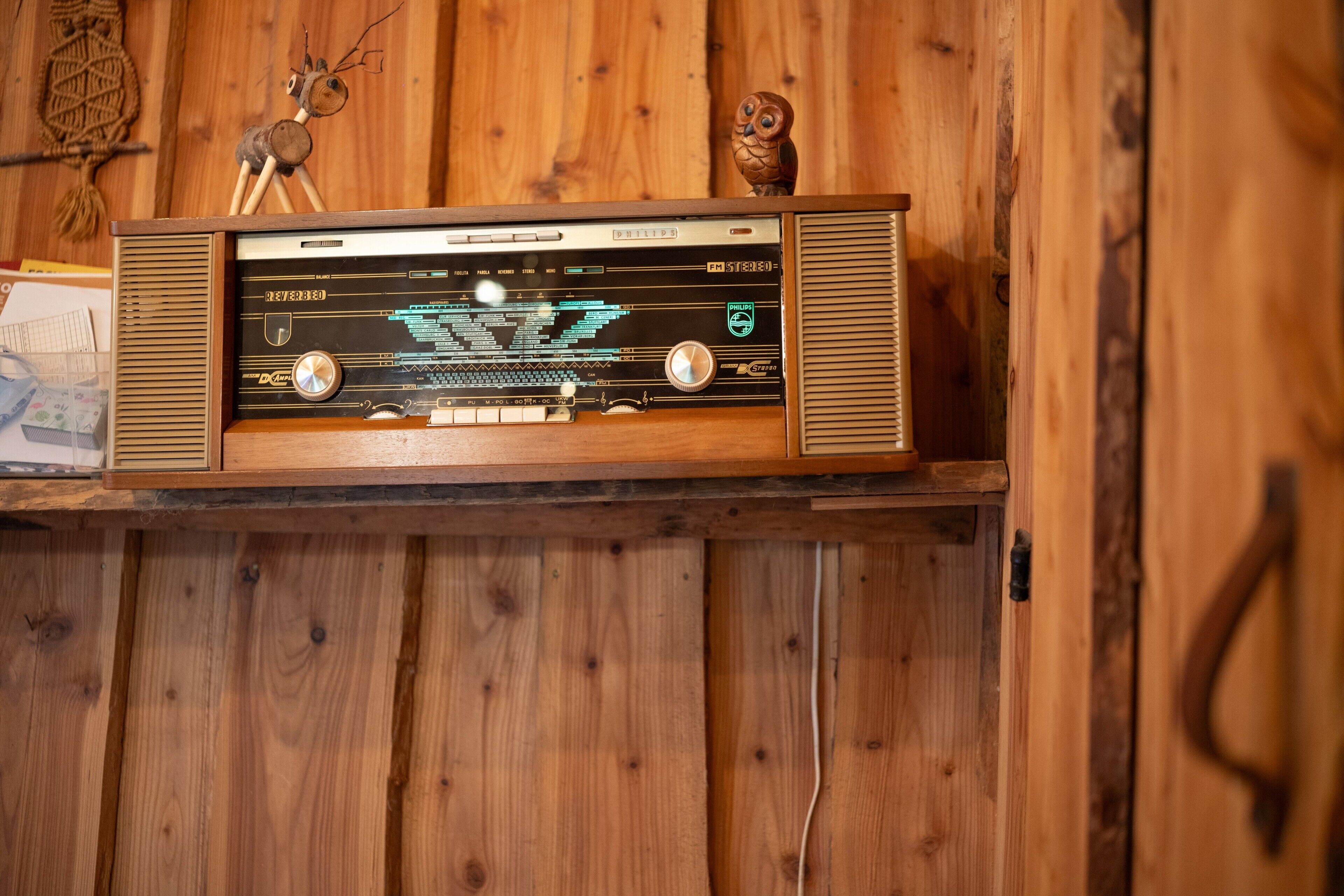 A wooden wall with a vintage radio on a shelf.