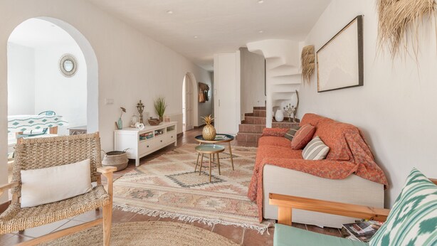 A spacious living area with a sofa, armchair, and a coffee table. - Holiday Home “Villa Sol Del Este, Es Castell” with Sea View, Wi-Fi and Air Conditioning (Sol del Este)