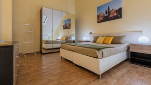 A bedroom with a bed, bedside tables, a wardrobe, a mirror, and a painting on the wall. - Loft San Carlo by Wonderful Italy (Turin)