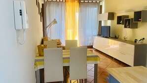 Un comedor con una mesa, sillas, una lámpara y un televisor.