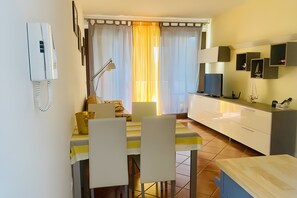 Un comedor con una mesa, sillas, una lámpara y un televisor.