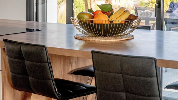 A modern dining area with a wooden table, black chairs, and a fruit bowl on the table. - Villa with jacuzzi, 5 bedrooms - ideal for families (Inzinzac-Lochrist)