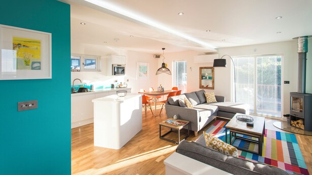 A modern living room with a sofa, coffee table, and a colorful rug. - Barbara (Redruth)