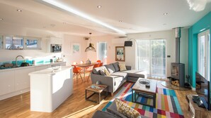 A modern living space with a kitchen, dining area, and seating area. - Barbara (Redruth)
