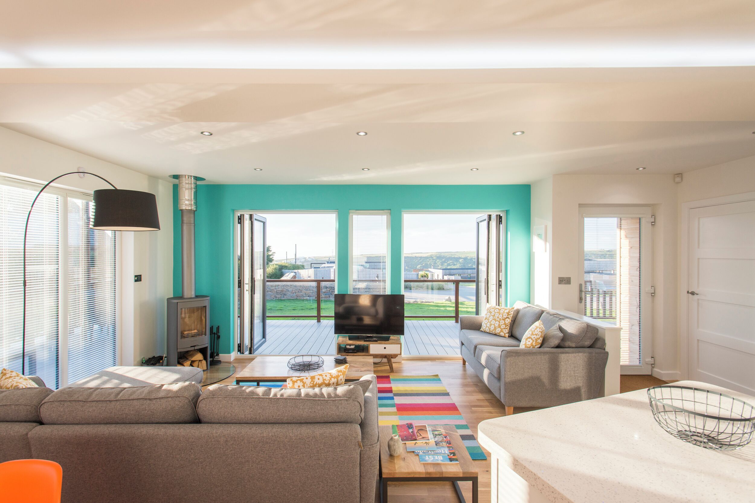 Una sala de estar moderna con un sofá, una mesa de centro, un televisor y una chimenea.
