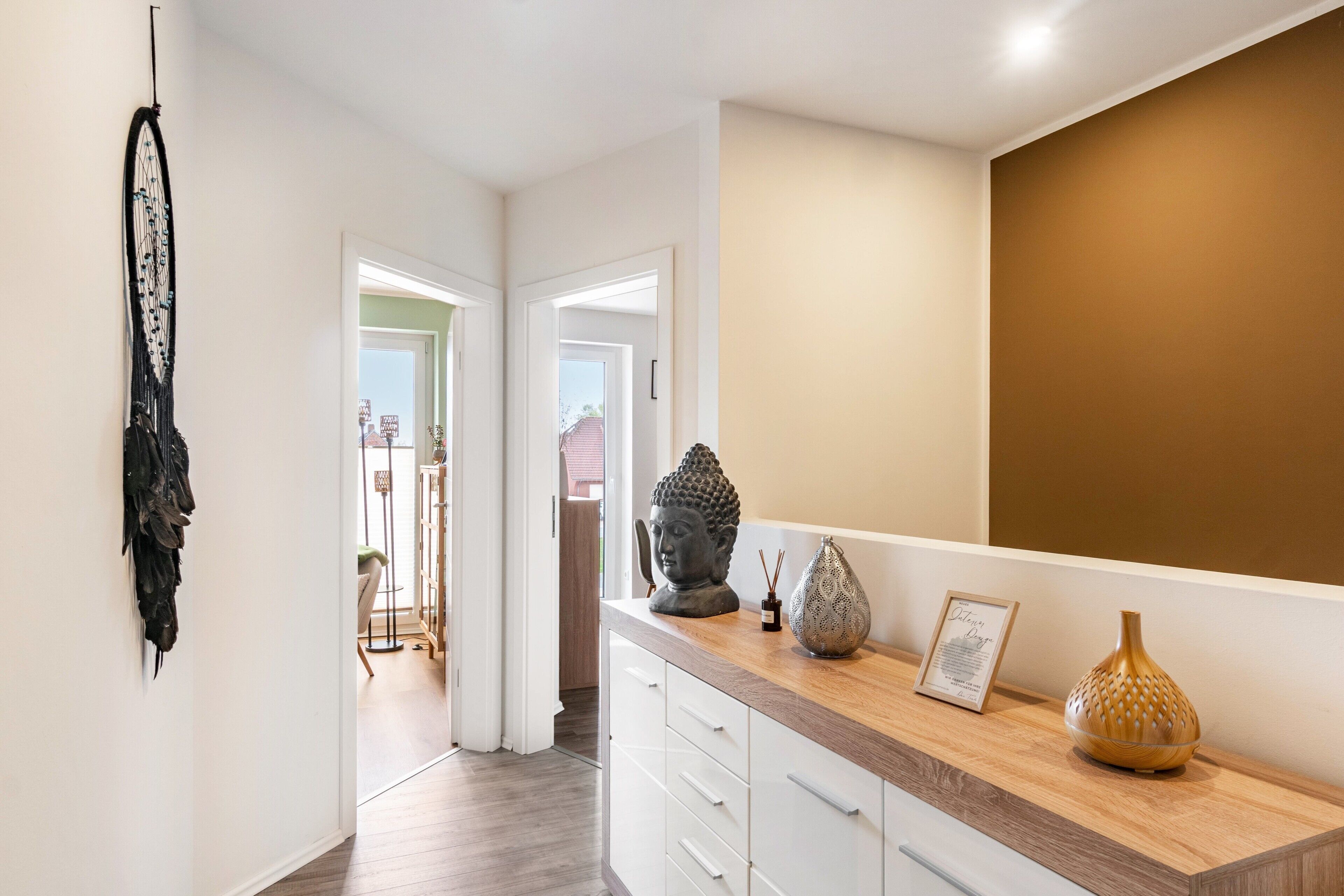 A hallway with a wooden counter, a Buddha statue, and a framed certificate.