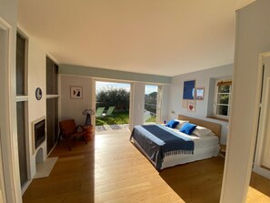 A bedroom with a bed, a chair, a fireplace, and a view of the outdoors. - "Moo Graugh Hoo" Villa (Châteauneuf-Grasse)