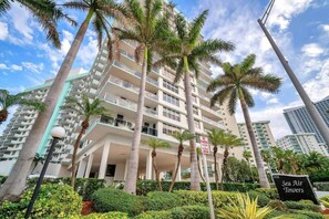 A multi-story hotel with balconies, palm trees, and a sign indicating 'Sea Air Towers.' - Newly renovated 2BR Beachfront (Hollywood)