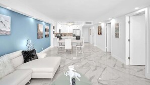 Een modern interieur met een witte bank, een eethoek en een keuken.