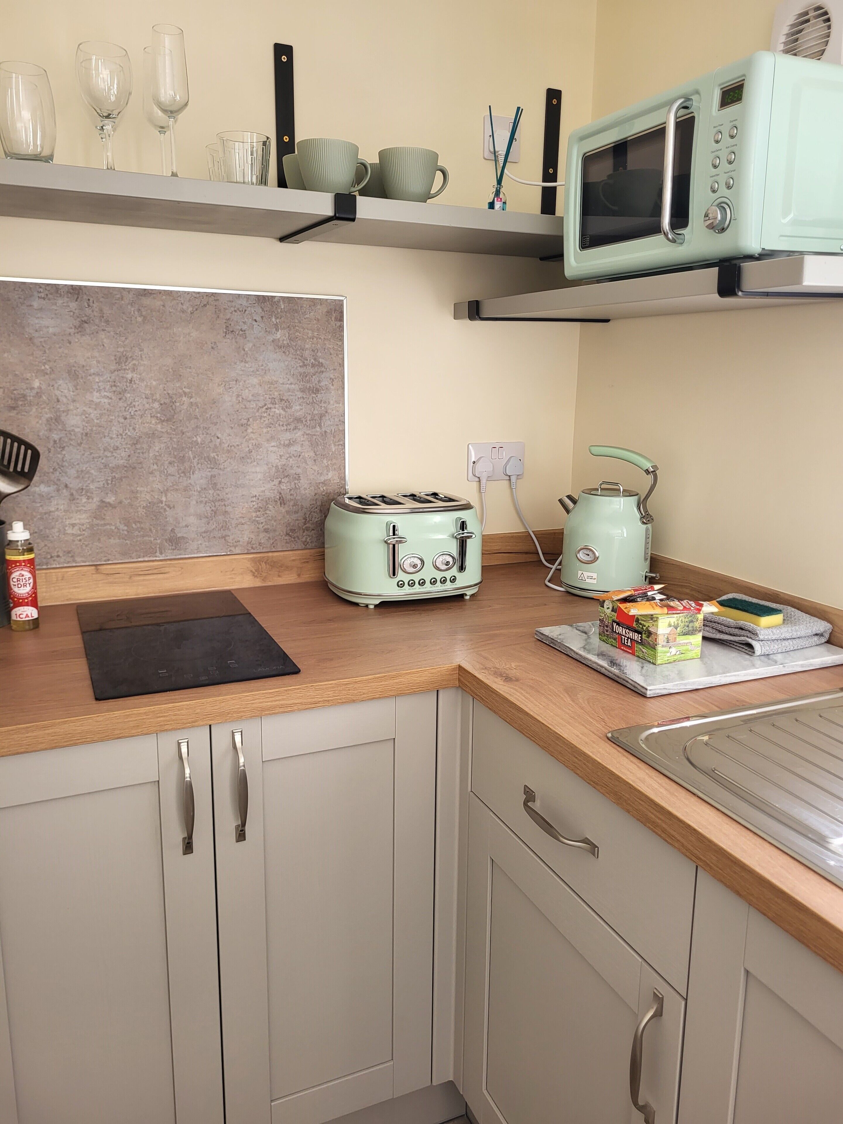 A kitchen with a toaster, kettle, and microwave on the counter.