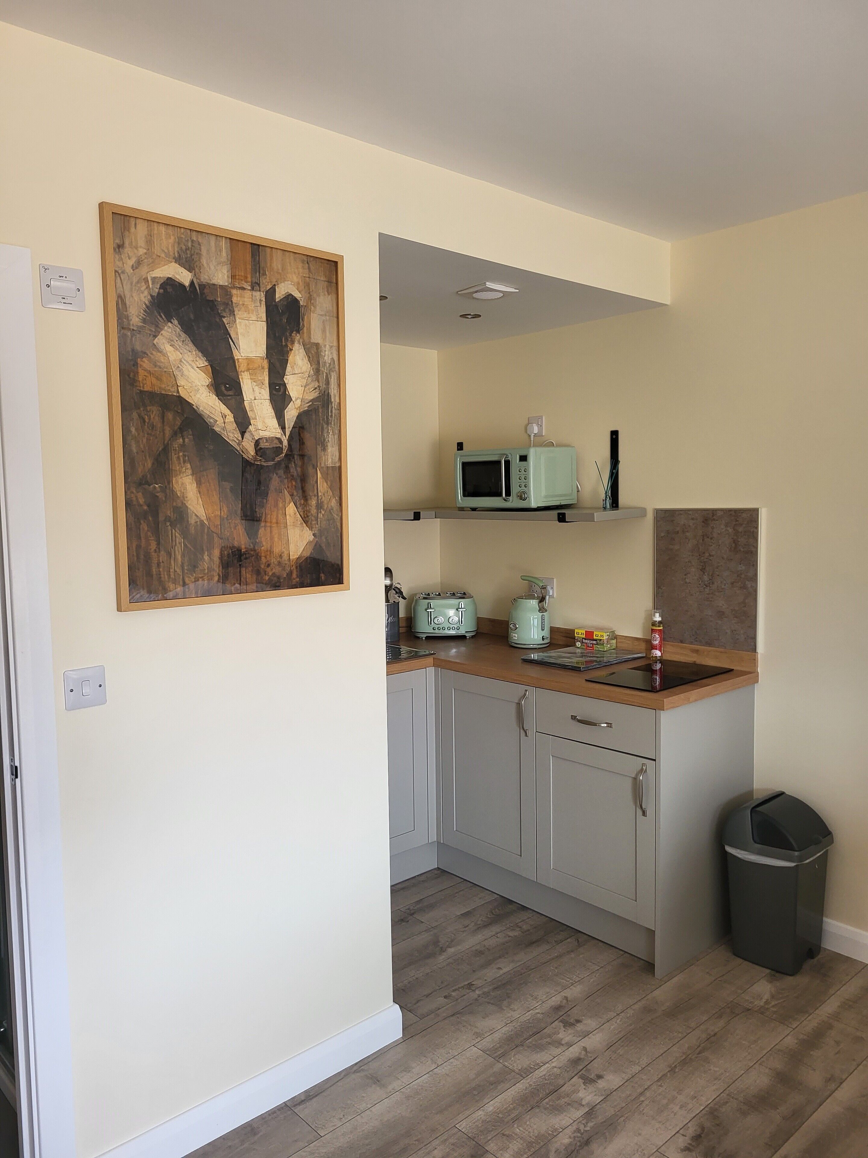 A kitchen with a microwave, toaster, and cabinets.