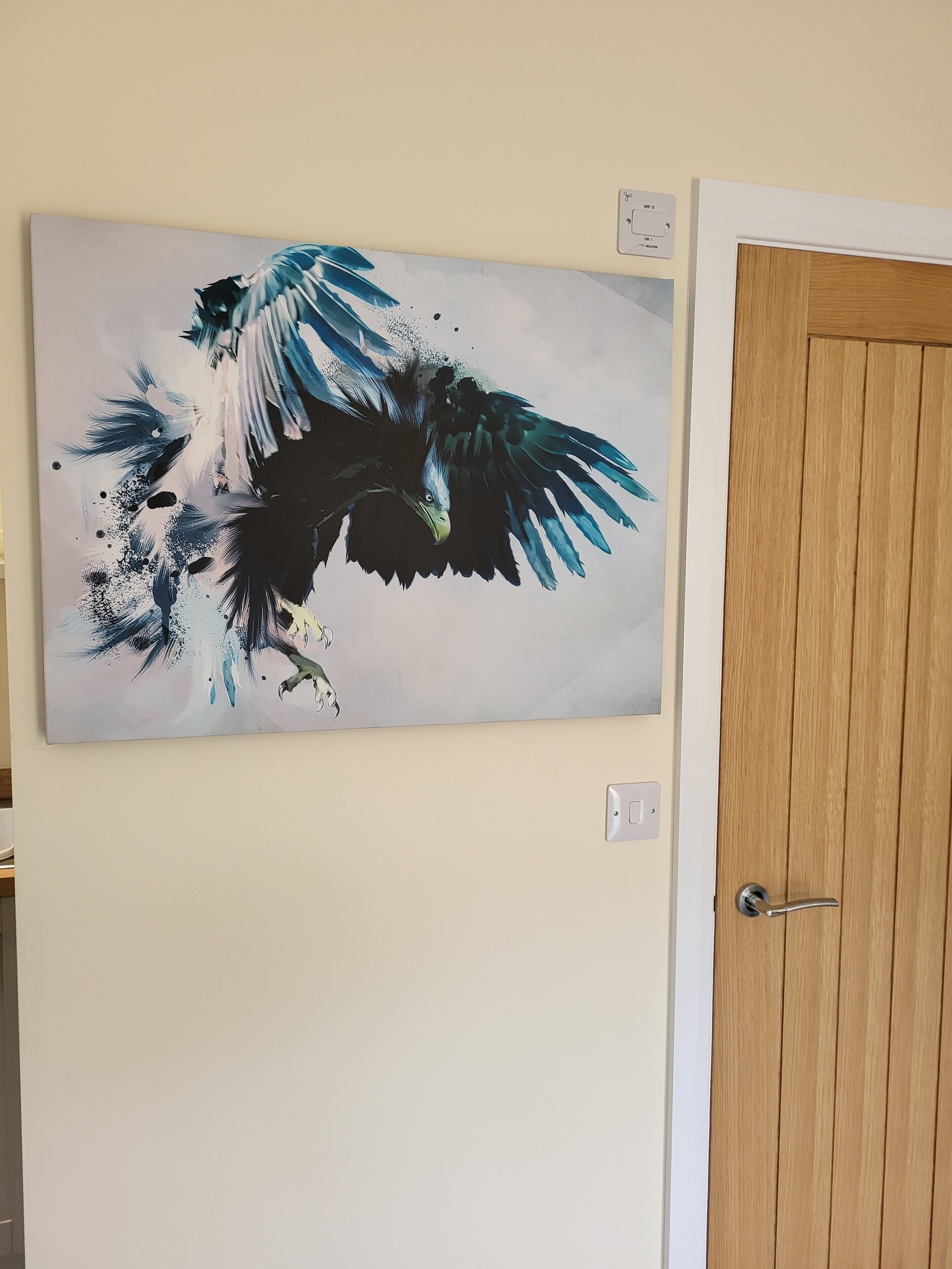 Un cuadro abstracto colgado en la pared que muestra un pájaro volando.