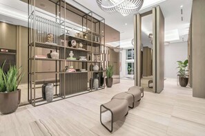 Ein modernes Interieur mit Glastrennwand, Sitzgelegenheit und Zimmerpflanzen.